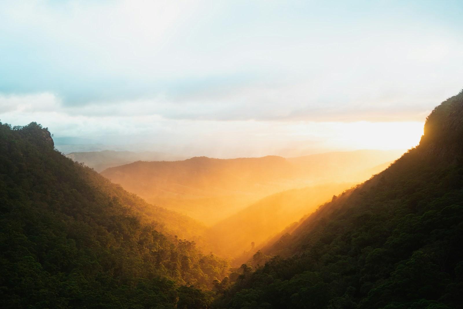 Sunlight falling across a wooded valley