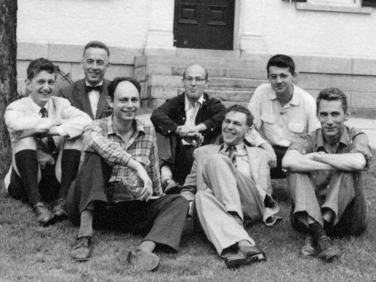 Eight attendees of the 1956 Dartmouth Summer Research Project on Artificial Intelligence, sitting on the grass outside a college building